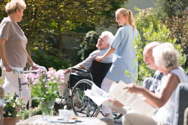 Residents and staff interacting in a garden area