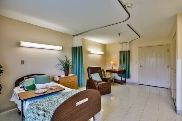 Private resident room with a bed and chair