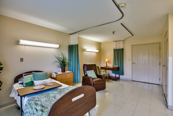 Private resident room with a bed and chair