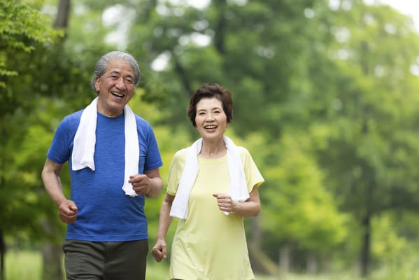 Two seniors jogging together on a path