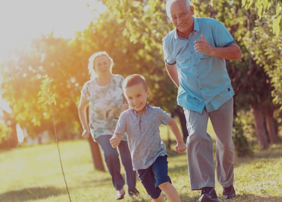 Seniors and a child running in a garden