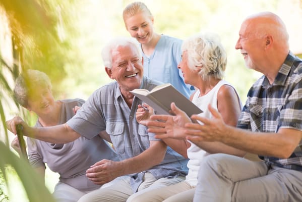 Residents enjoying a book reading activity outdoors