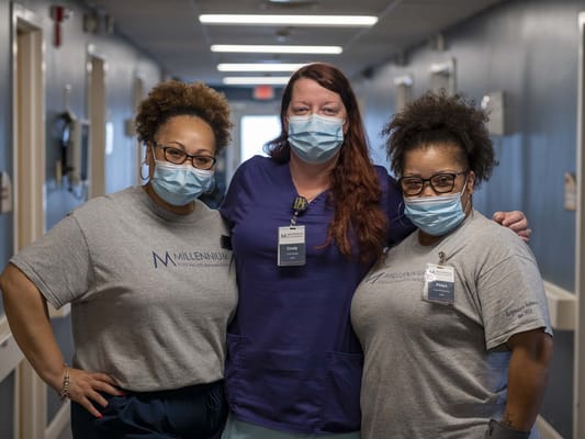 Three staff members wearing masks in a hallway