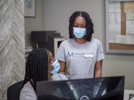 Staff assisting each other at a reception desk