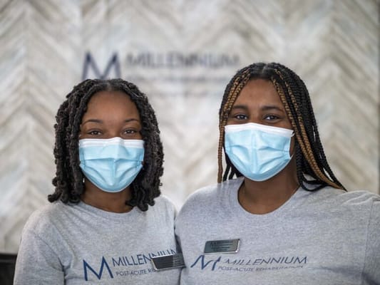 Two staff members in Millennium Post Acute Rehabilitation uniforms