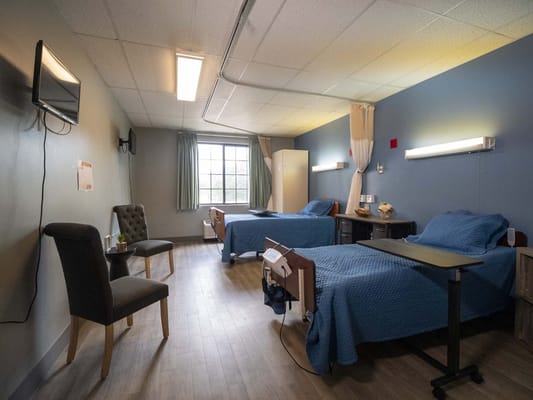 Private resident room with two beds and a window