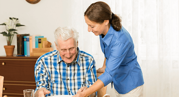 Staff member serving food to a smiling resident