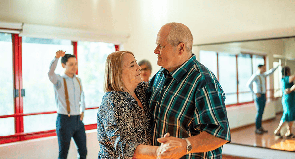 Residents dancing together in an activity room