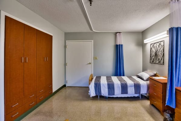 Clean and simple resident room with a bed and storage