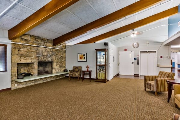 Interior common area with chairs and a stone fireplace