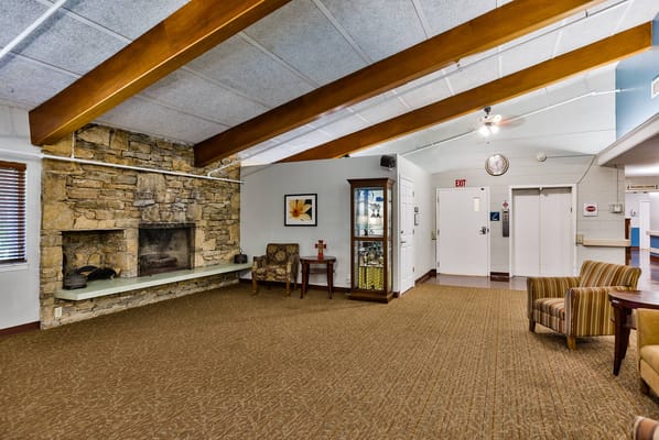 Interior common area with chairs and a stone fireplace