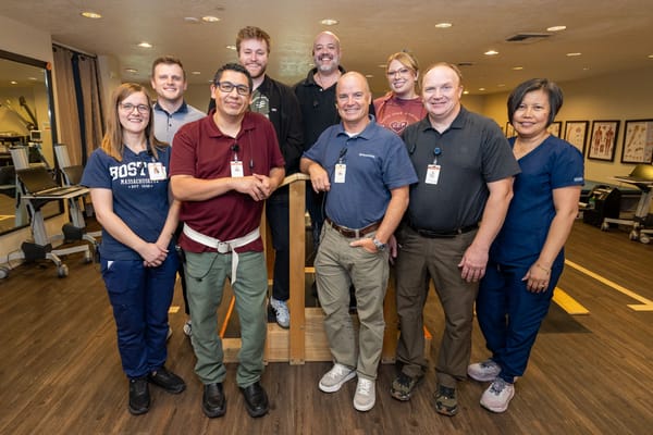 Staff members posing together in a bright activity room