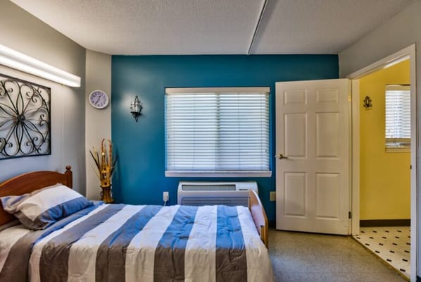 Brightly decorated resident room with a bed and bathroom