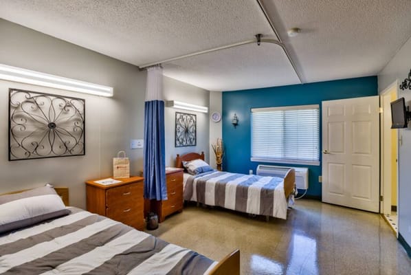 A shared resident room with two beds and decor