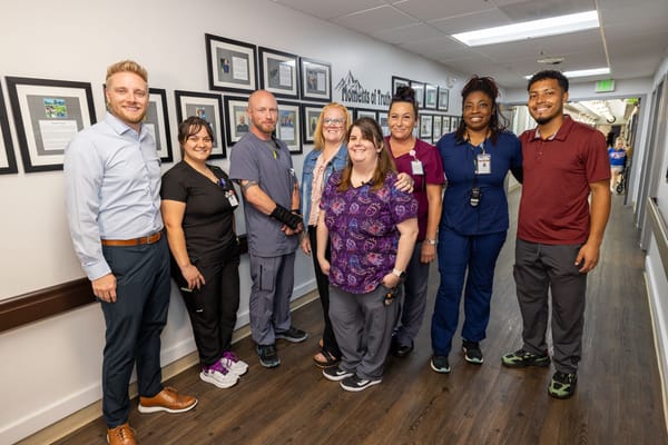 Staff members posing for a photo in a hallway