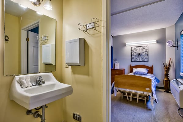Private resident room with bed and wash basin.