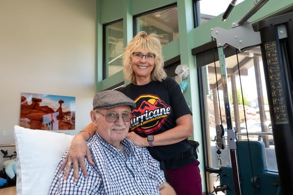 Staff member posing with a resident in a bright interior