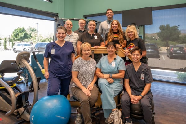 Staff members posing together in a facility activity area