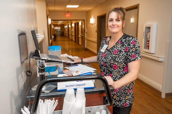 Staff member assisting in a facility hallway