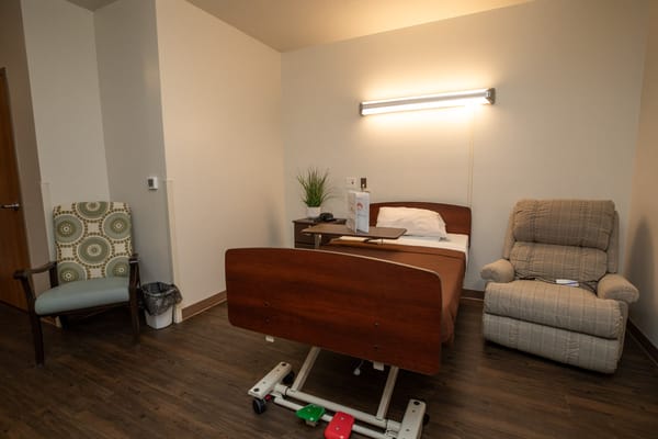 A private resident room with a hospital bed and seating