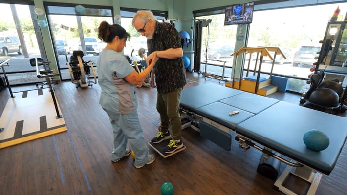 A staff member assisting a resident with physical therapy