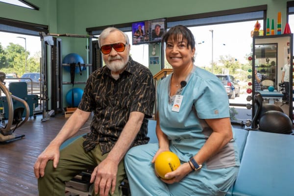 A resident and staff member in a therapy room
