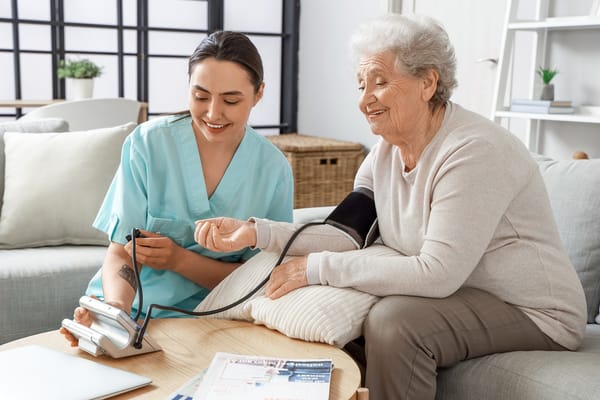 A caregiver taking a senior's blood pressure