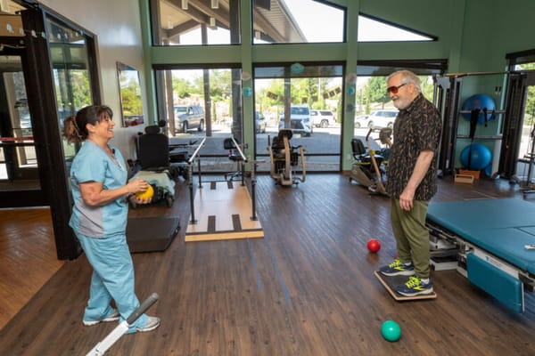 Therapist assisting a resident in a rehab activity area