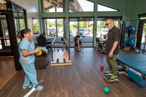 Therapist assisting a resident in a rehab activity area