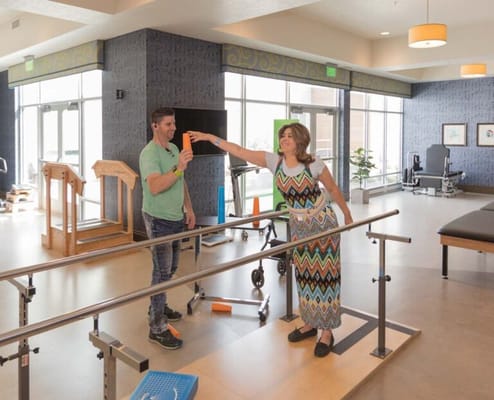 Therapist assisting a resident in a bright rehabilitation area