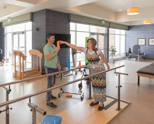 Therapist assisting a resident in a bright rehabilitation area