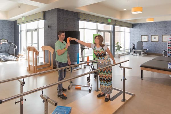 Therapist assisting a resident in a rehabilitation area