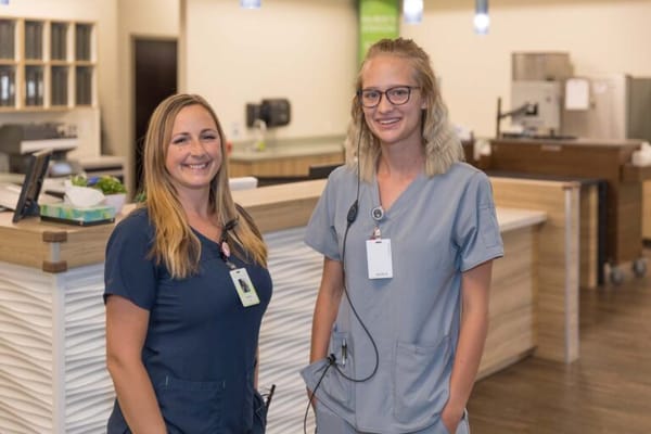 Two staff members smiling in a facility common area