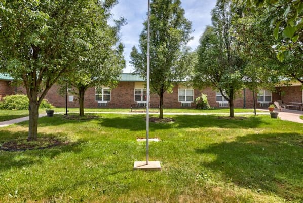 Outdoor space with trees and seating at Cameron Nursing Center