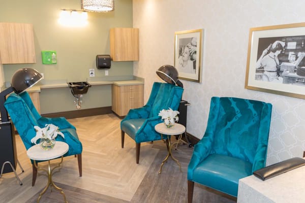 Interior lounge area with teal chairs and decorative photos