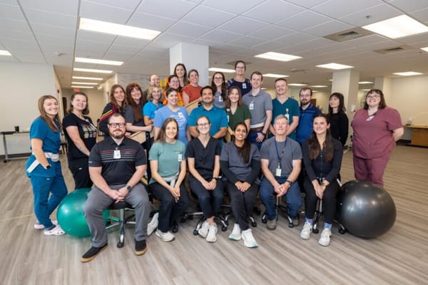 Group photo of staff members in a bright facility interior