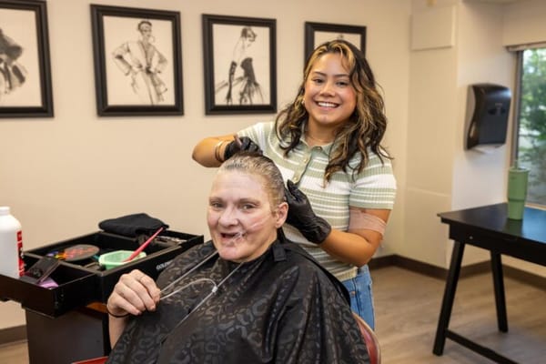 Resident receiving a haircut from a staff member in the salon