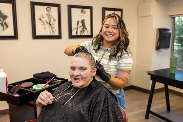 Resident receiving a haircut from a staff member in the salon