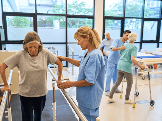 Residents engaging in physical therapy with staff support