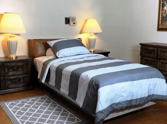 Cozy bedroom with warm lighting and a striped comforter