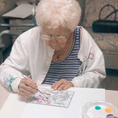 Resident engaged in a painting activity at a table