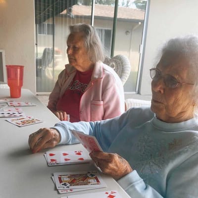 Two residents playing cards at a table