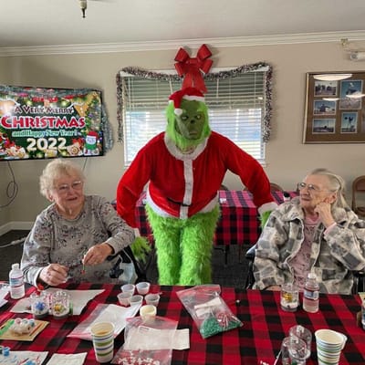 Residents with costumed character in a decorated room