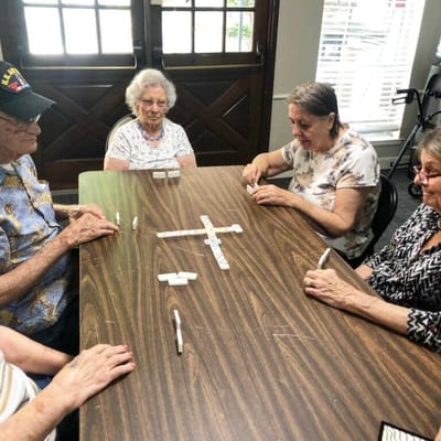 Residents playing dominoes around a table