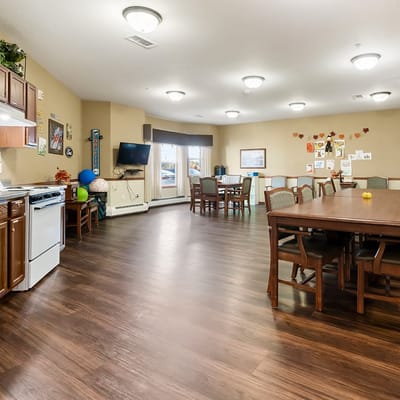 A bright common area with dining tables and kitchen