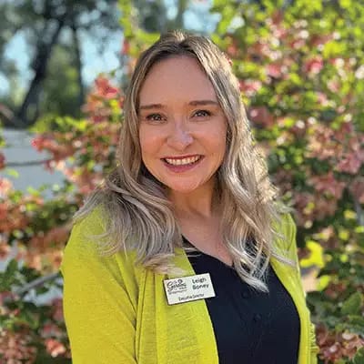 Staff member smiling in a garden setting