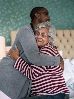 Two residents sharing a warm hug in a cozy room