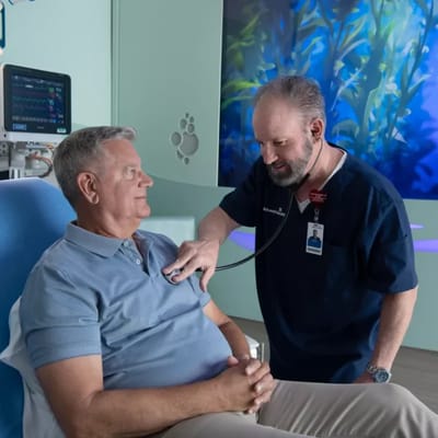 Healthcare staff checking on a resident in a bright room