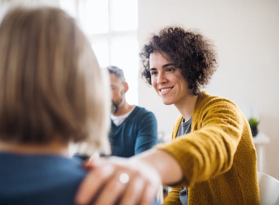 A staff member engaging with a resident in a bright room