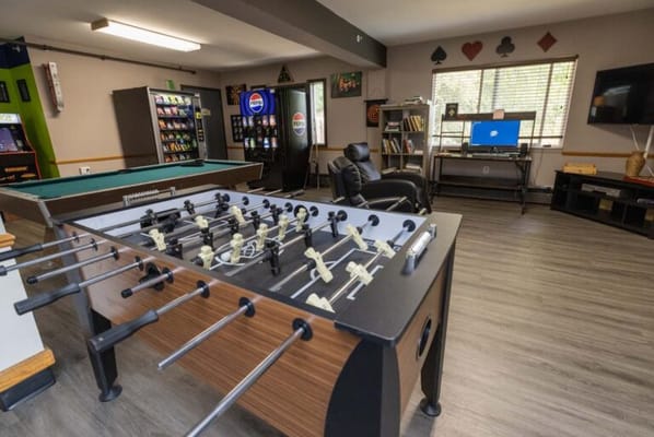 Activity room featuring foosball and gaming machines